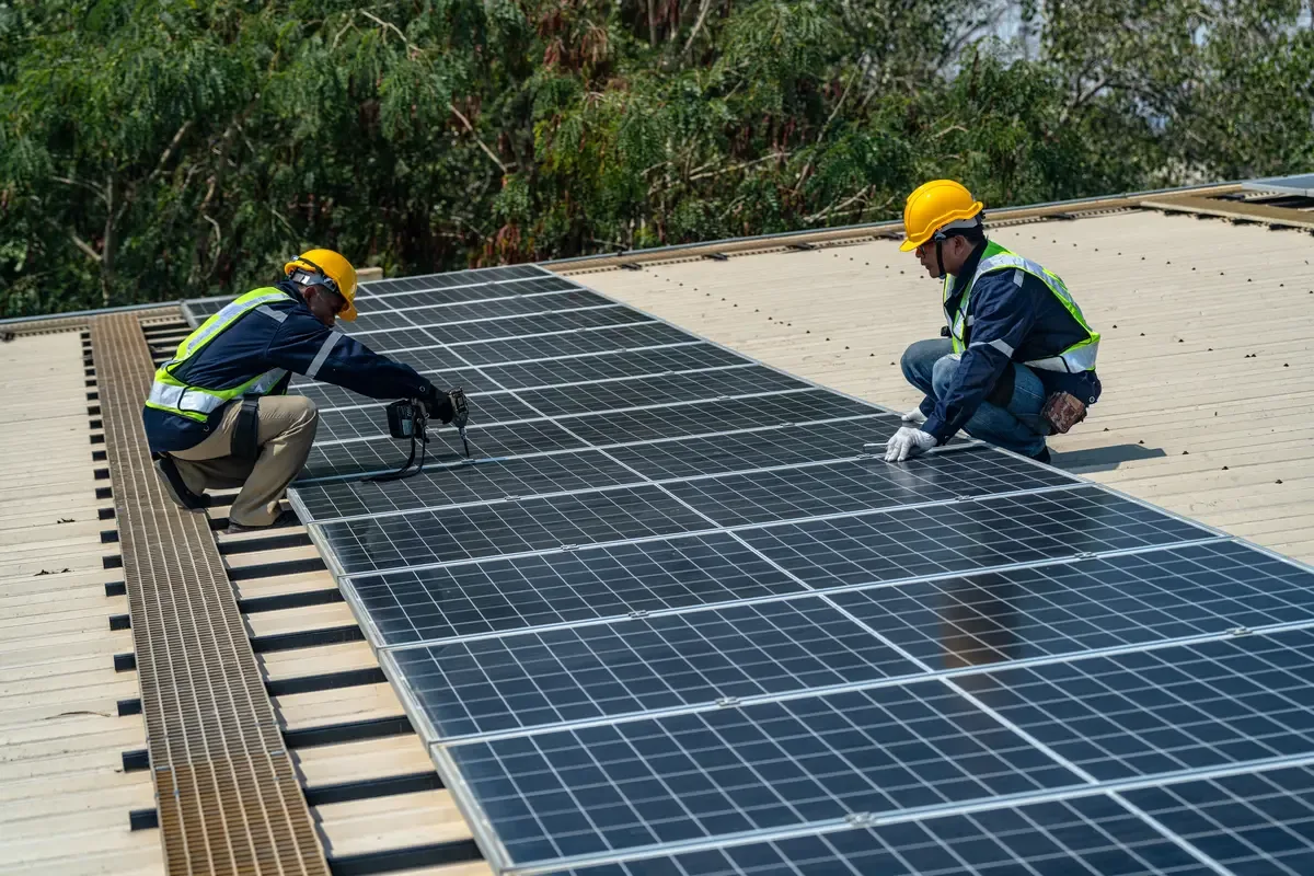 Dos técnicos montando placas solares sobre una cubierta metálica durante una instalación en Sabadell